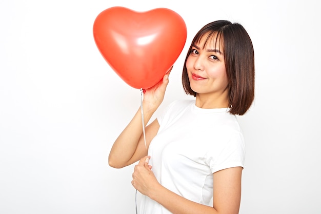 Femme asiatique tenant un ballon coeur rouge