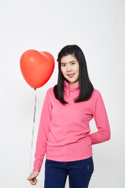 Femme asiatique tenant un ballon coeur rouge