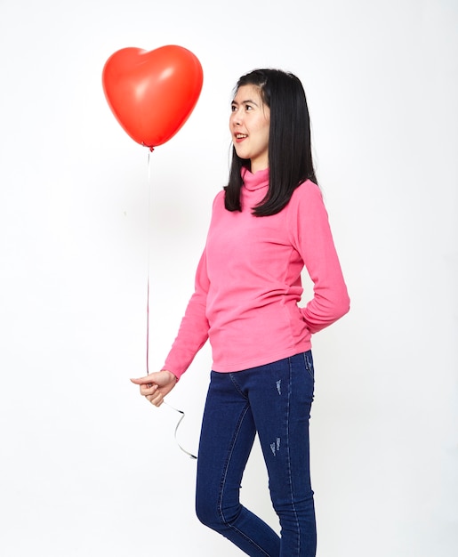 Femme asiatique tenant un ballon coeur rouge