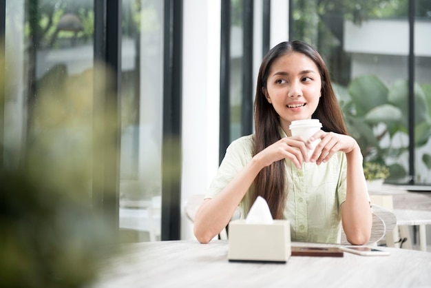 Femme asiatique tenant un café dans le café