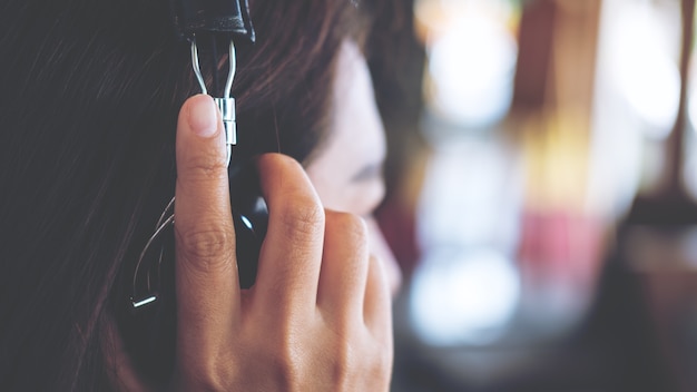 Une femme asiatique tenant un casque et écouter de la musique