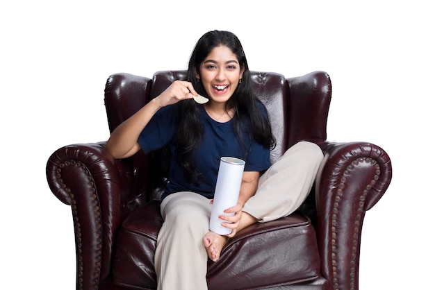 Femme asiatique tenant une collation assise sur le canapé