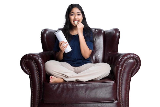 Femme asiatique tenant une collation assise sur le canapé