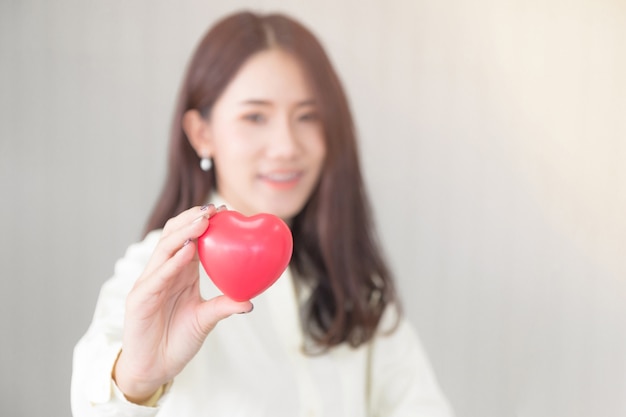 Femme asiatique tenant la forme de coeur d&#39;amour. Concept de soins de santé.