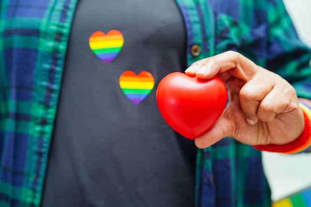 Femme asiatique tenant un hert rouge avec drapeau arc-en-ciel Symbole LGBT droits et égalité des sexes Mois de la fierté LGBT en juin