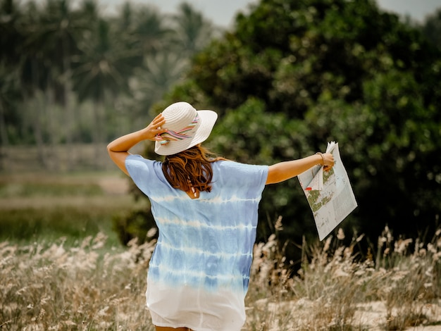 Femme asiatique sur le terrain avec concept de voyage de carte