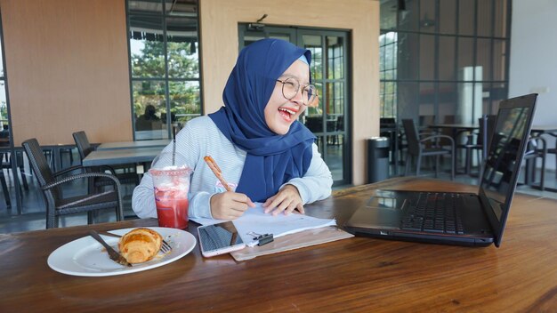 Une femme asiatique tient une réunion par conférence téléphonique vidéo