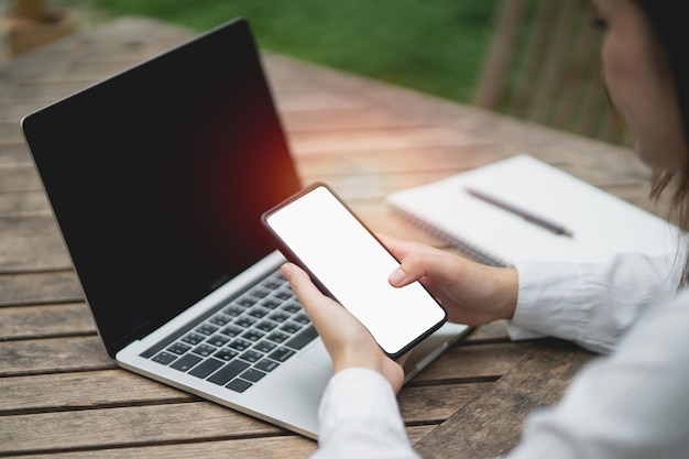 Une femme asiatique tient un texte de téléphone portable ou un message sur un écran blanc