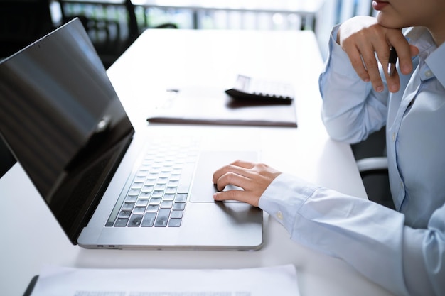 Femme asiatique travaillant à l'aide d'un ordinateur portable, tapant à la main sur le clavier, travaillant au bureau, investisseur professionnel, nouvelle start-up.