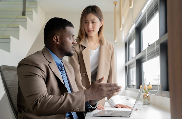 Photo une femme asiatique travaillant avec un homme d'affaires africain.