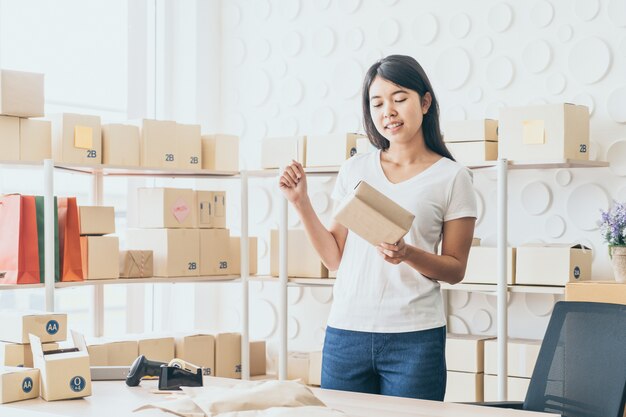 Femme asiatique travaillant à la maison avec des boîtes d'emballage