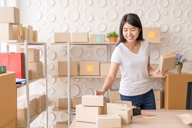 Femme asiatique travaillant à la maison avec des boîtes d'emballage