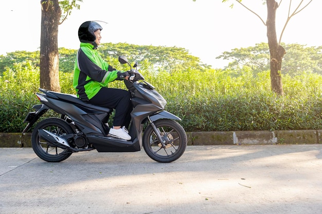 Une femme asiatique travaille comme chauffeur de moto-taxi