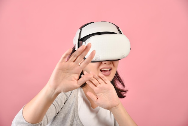 Photo femme asiatique utilisant des lunettes vr regarder un film et jouer à des jeux vidéo à partir d'un casque de réalité virtuelle jeune femme effrayée par une nouvelle expérience par la technologie vr prise de vue en studio