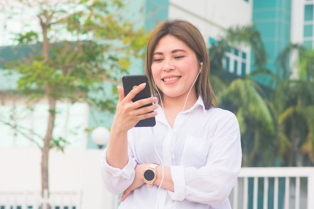 Femme asiatique utilise un smartphone pour écouter de la musique