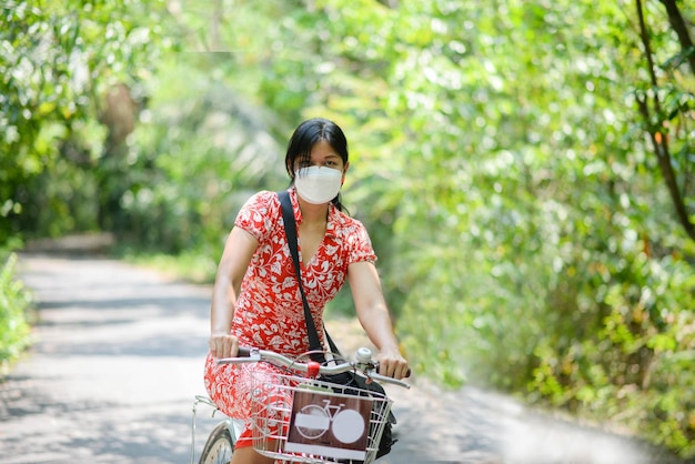 Femme asiatique à vélo dans le parc de la ville