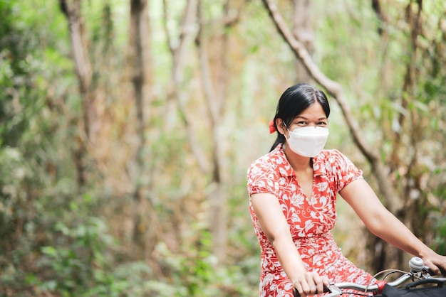 Femme asiatique à vélo dans le parc de la ville