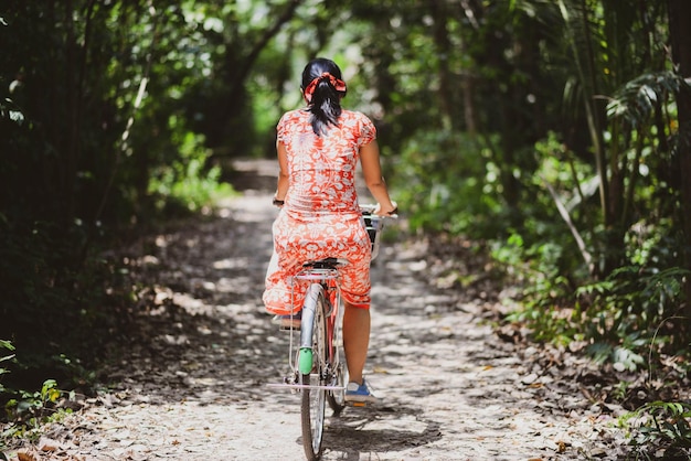 Femme asiatique à vélo dans le parc de la ville