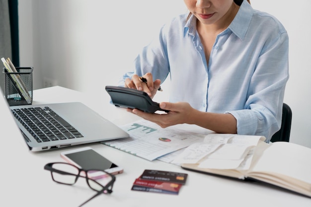 Femme asiatique vérifiant les factures taxes solde du compte bancaire et calculant les dépenses de carte de crédit Concept de planification financière familiale Gros plan