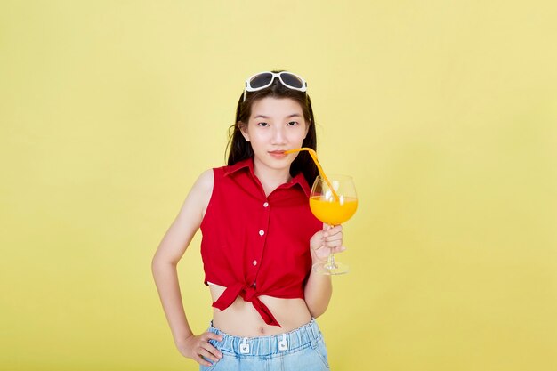 Femme asiatique en vêtements décontractés d'été avec un verre de jus de fruits frais