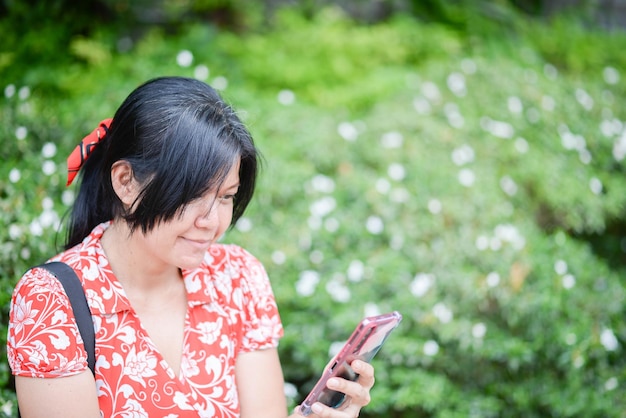 Femme asiatique voyageant dans le parc de la ville avec un sourire heureux