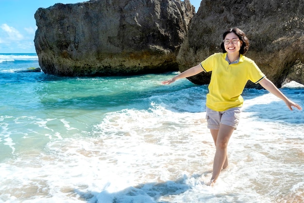 Femme asiatique voyageant sur la plage