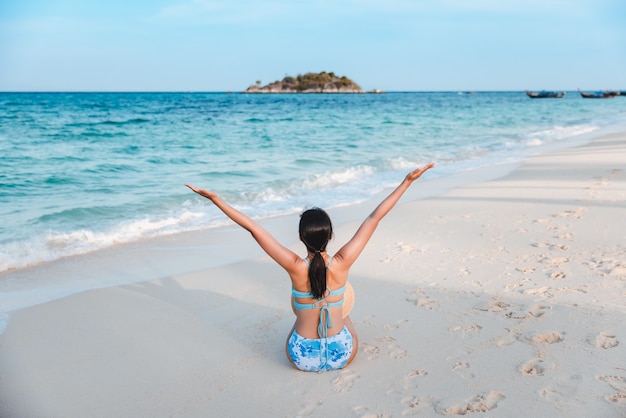 Femme asiatique de voyageur avec le bikini et le chapeau détendant sur la plage de mer au jour dans Koh Lipe, Satun, Thaïlande