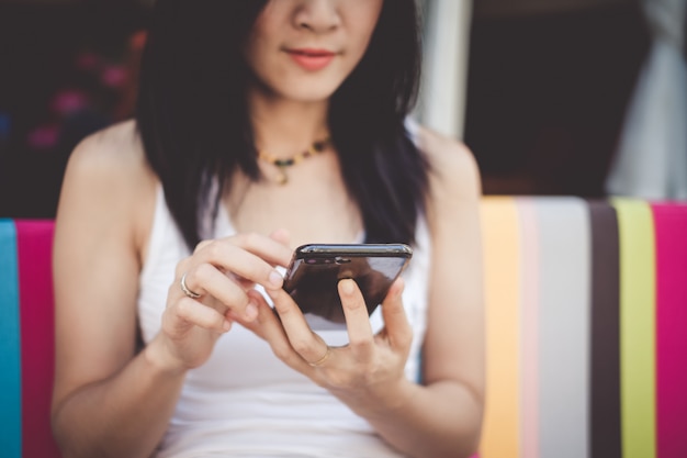 Femme d&#39;Asie à l&#39;aide d&#39;un téléphone portable pour vérifier les médias sociaux