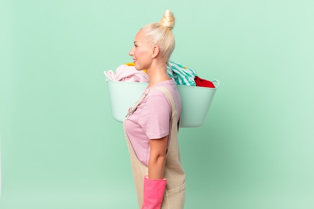 Femme assez blonde sur la vue de profil pensant, imaginant ou rêvant le concept de lavage de vêtements