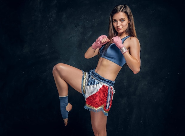 Une femme assez forte démontre sa pose de kick boxer tout en posant pour le photographe.