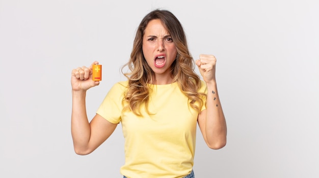 Femme assez mince criant agressivement avec une expression fâchée et tenant des batteries