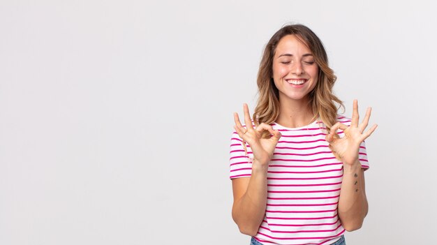 Femme assez mince qui a l'air concentrée et médite, se sent satisfaite et détendue, pense ou fait un choix