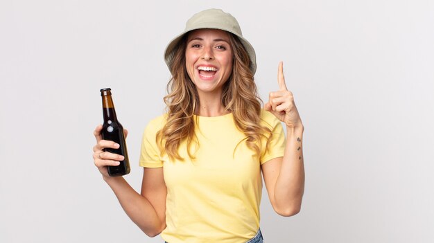 Femme assez mince se sentant comme un génie heureux et excité après avoir réalisé une idée et tenu une bière. concept d'été