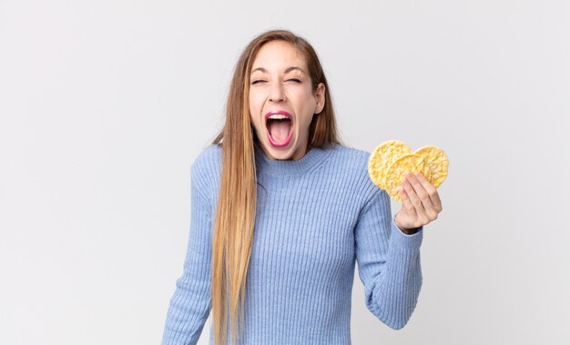 Femme assez mince tenant des gâteaux de régime de riz