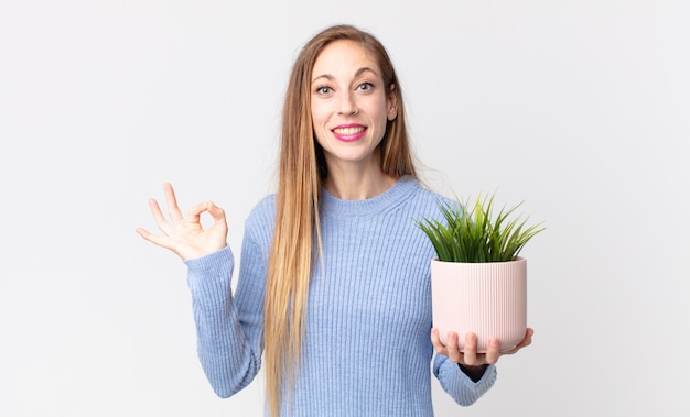 Femme assez mince tenant une plante d'intérieur décorative