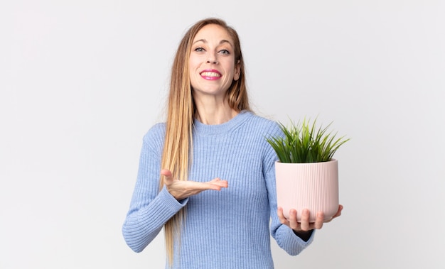 Femme assez mince tenant une plante d'intérieur décorative