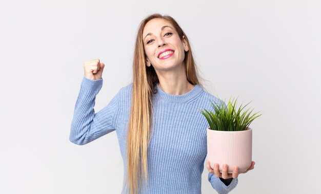 Femme assez mince tenant une plante d'intérieur décorative