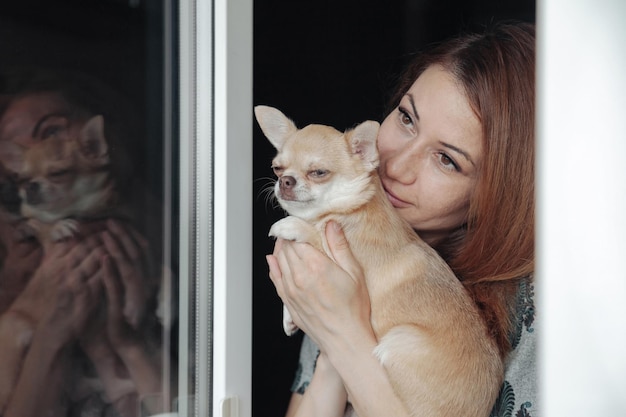 Femme assez mûre avec le chien de Chihuahua dans des mains