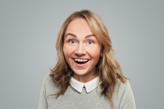 Une femme assez surprise sur un portrait de fond blanc