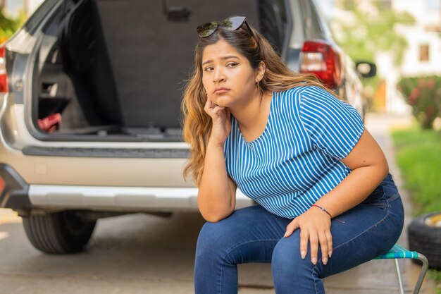 Photo une femme assise à l'attente que le remorqueur vienne récupérer son véhicule en ruine.