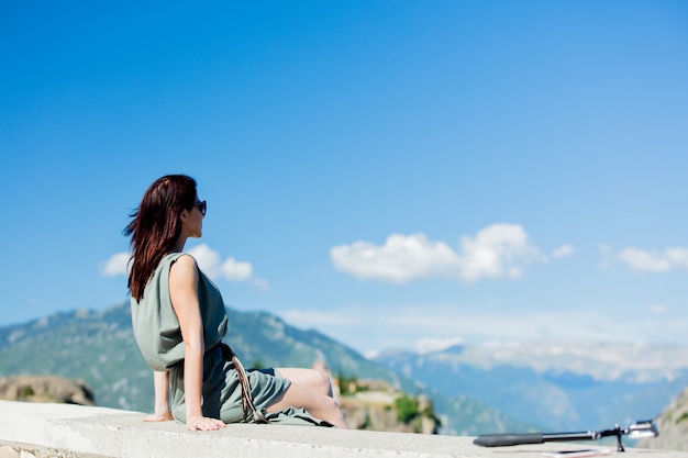 Femme assise au bord du précipice en Grèce