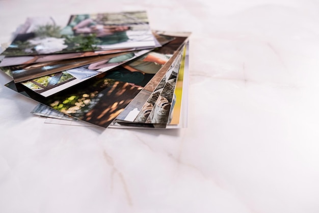 Une femme assise au bureau et regardant des photos imprimées se souvient de la nostalgie d'une journée de repos photographie fond de cartes maquette