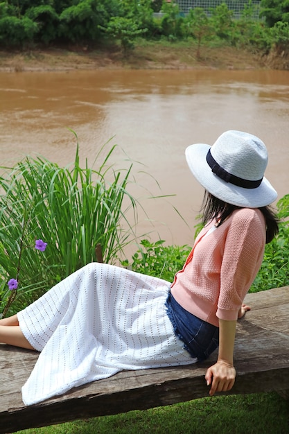 Femme assise au soleil sur le banc de la rivière Nan, province de Nan en Thaïlande