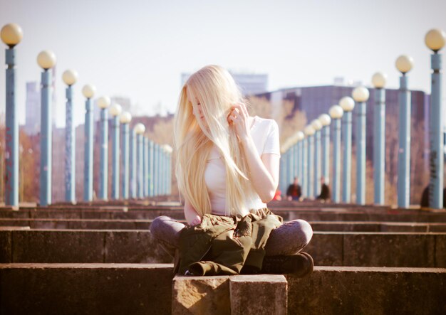 Photo une femme assise sur une balustrade contre le ciel.