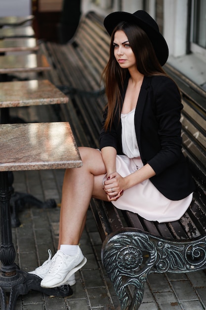 Une femme assise sur un banc en bois. Photo de haute qualité