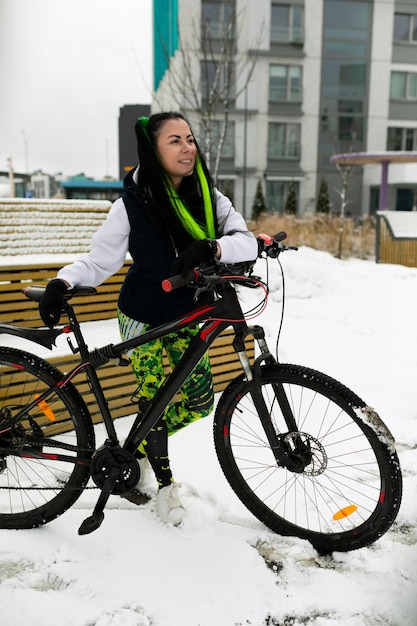 Une femme assise sur un banc à côté du vélo.