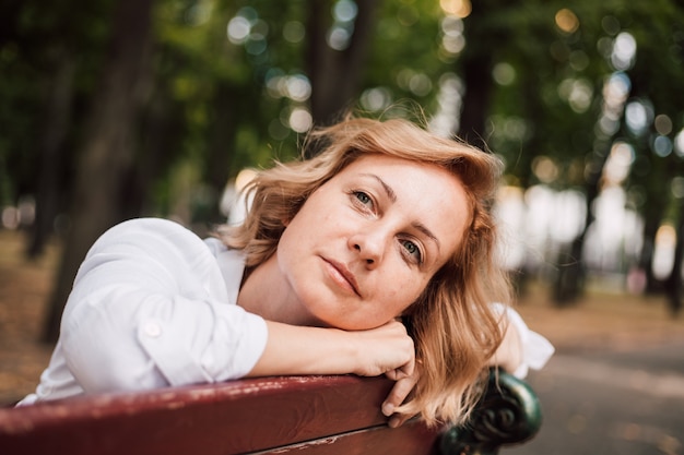 Une femme assise sur un banc de parc