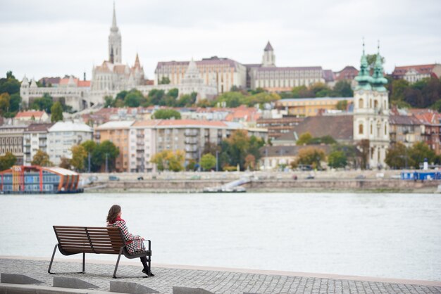 Femme assise sur un banc près d'une rivière