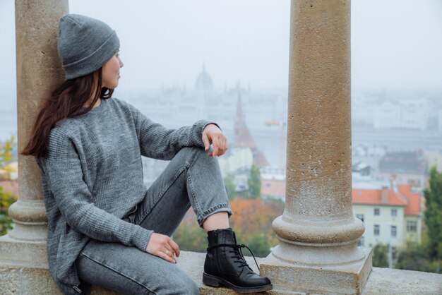 Femme assise avec une belle vue sur budapest dans la brume