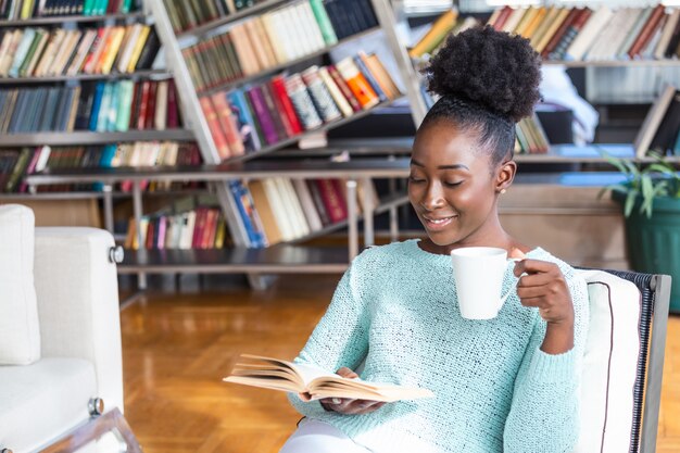 Femme assise et boire du café en lisant un livre